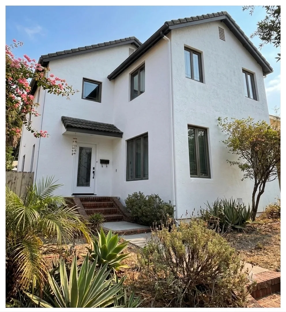 Stucco home exterior after washing, restored to a clean white finish